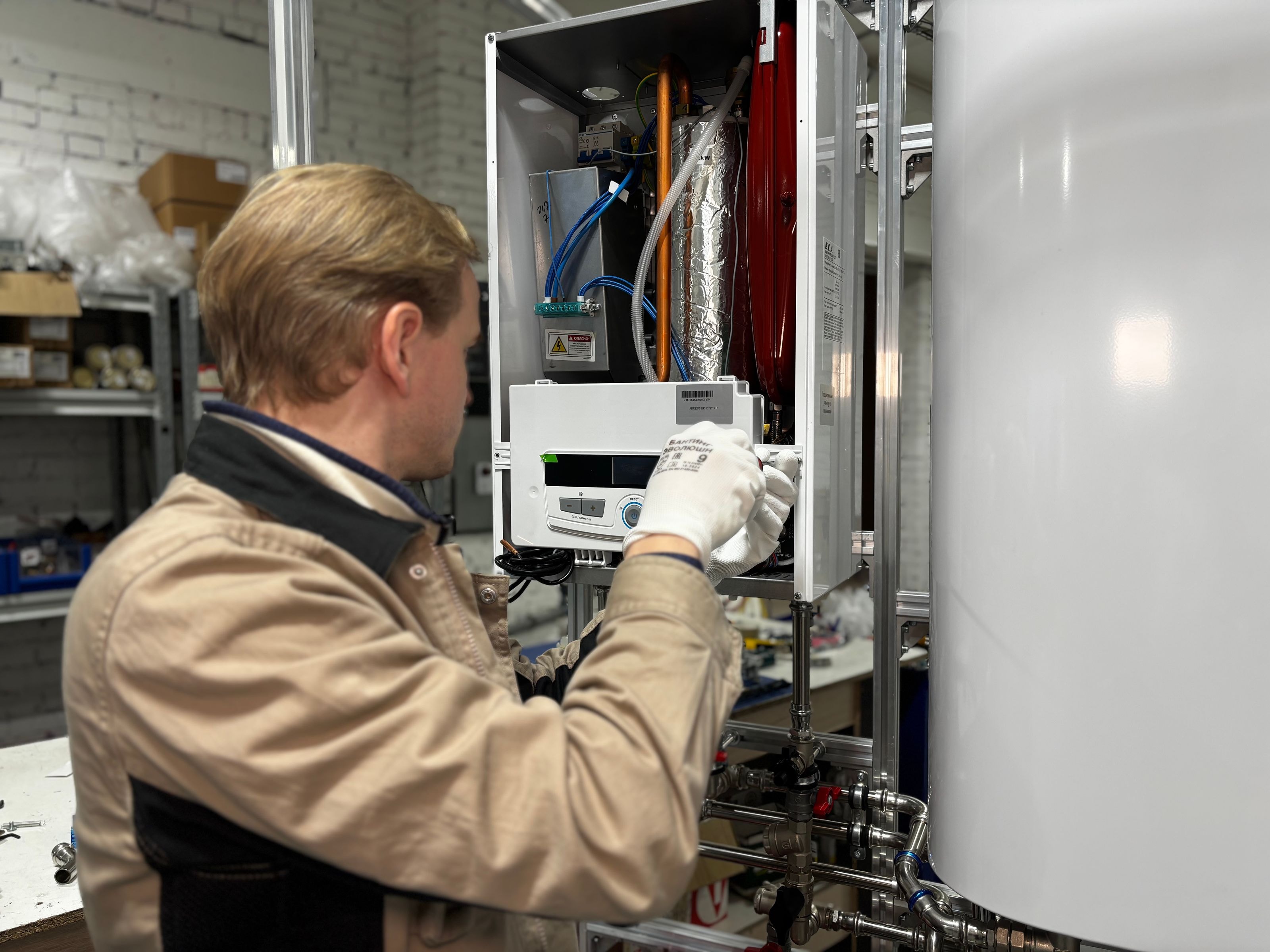 Technician working on heating equipment and its pipework