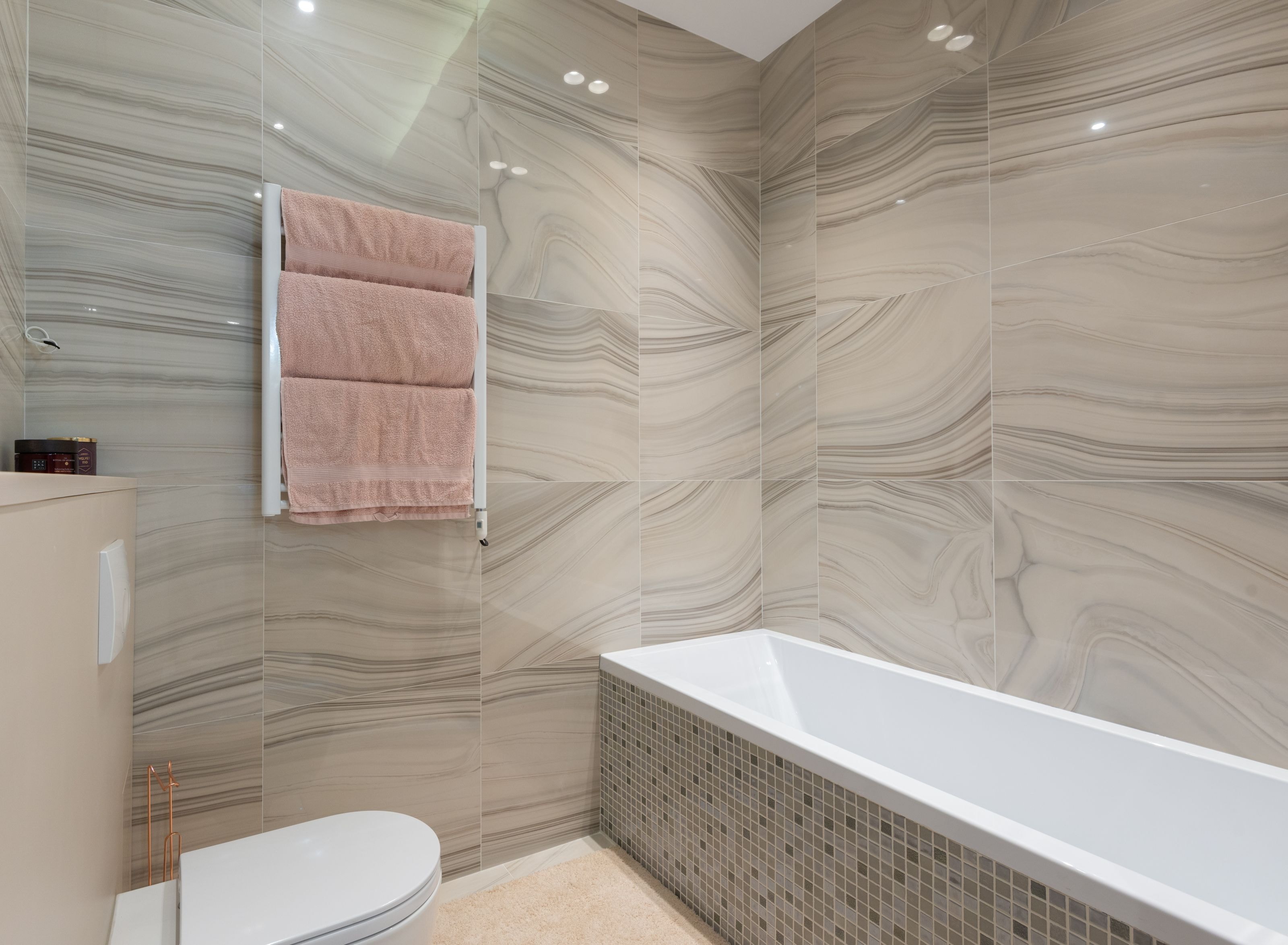 Modern fitted bathroom with a bathtub, tiling and towel radiator