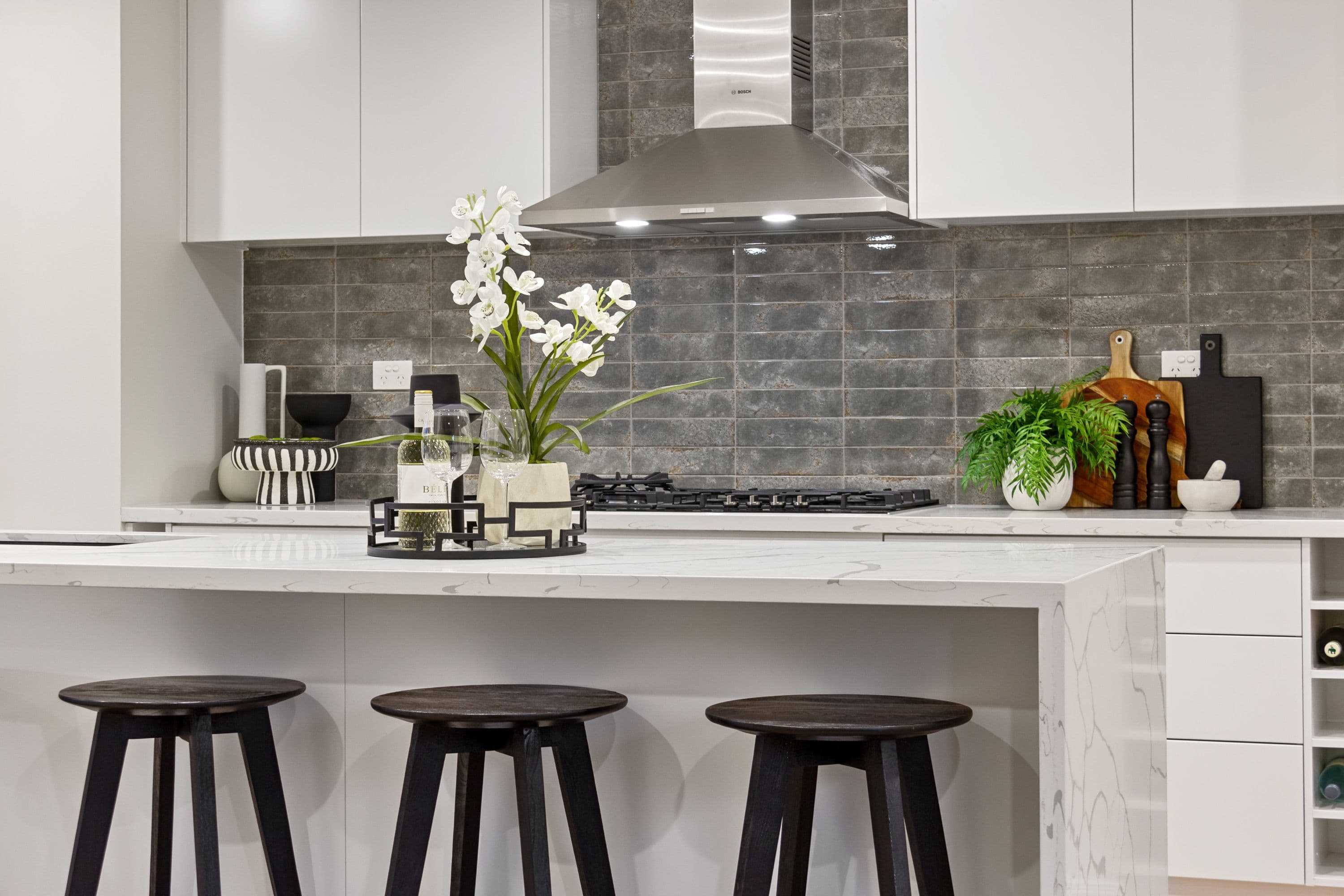 Fitted kitchen with cabinetry, a gas hob and a marble island